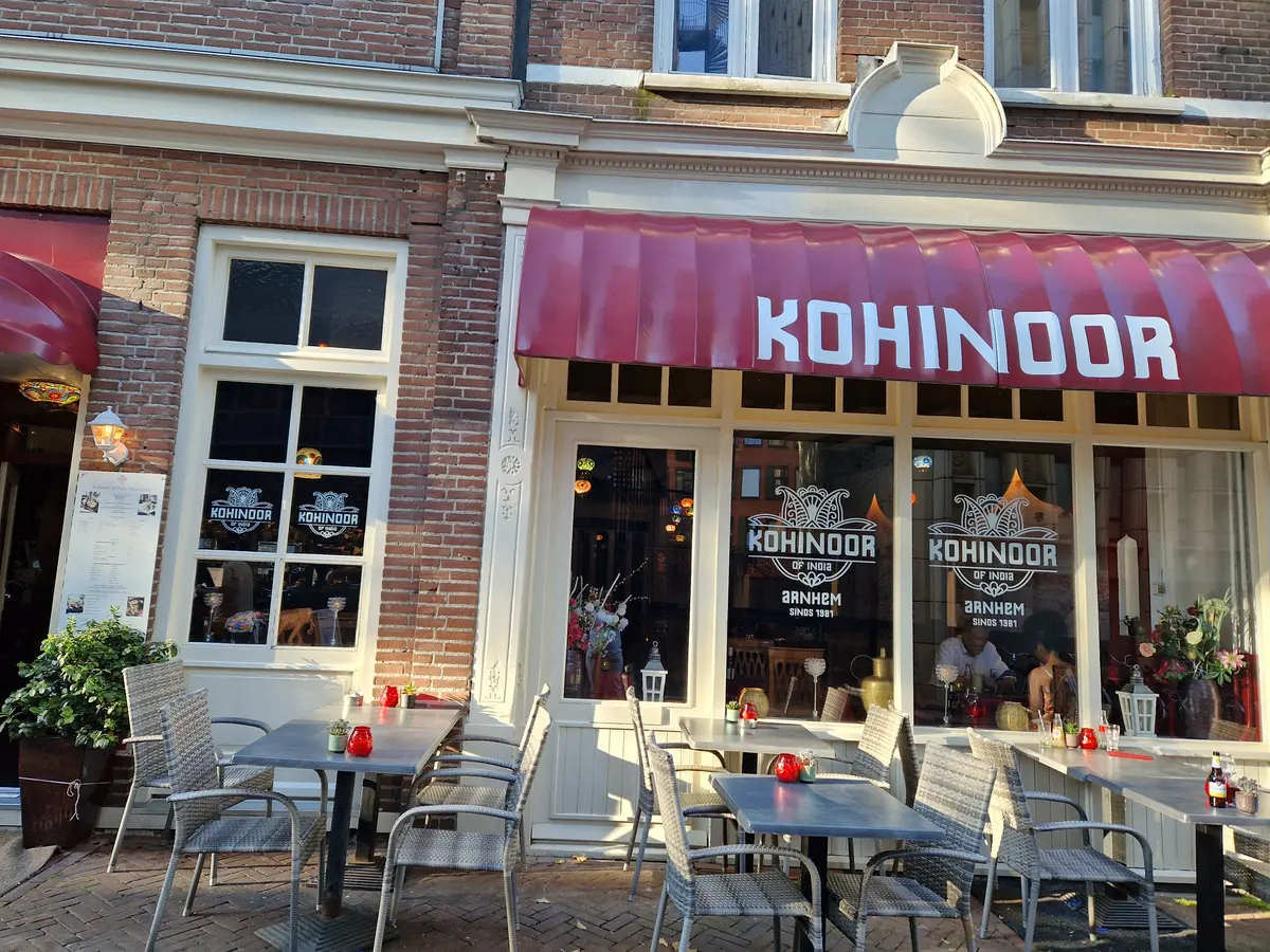 De gevel met rode luifel en het terras aan de Oude Oeverstraat in Arnhem