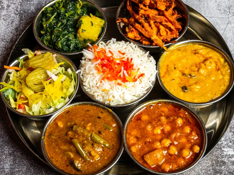 Een thali, een ronde schaal met zeven kleine gerechten, rijst en salade